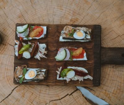 Top view of holiday appetizers on a wooden board with festive elements, creating a cozy rustic feel.